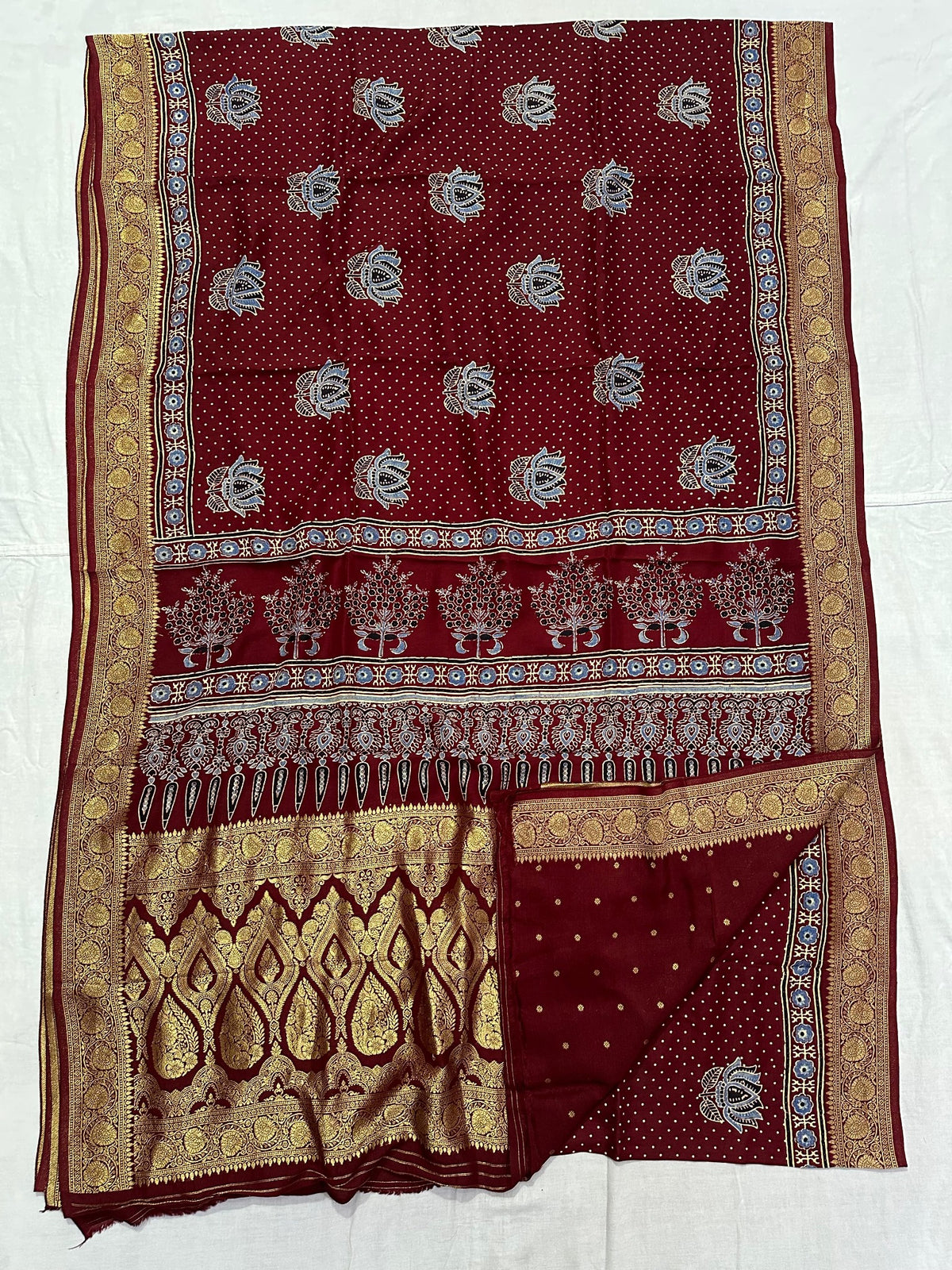 Maroon Dola silk Ajrakh handblocked saree with floral motifs, tree border and rich gold zari-style pallu