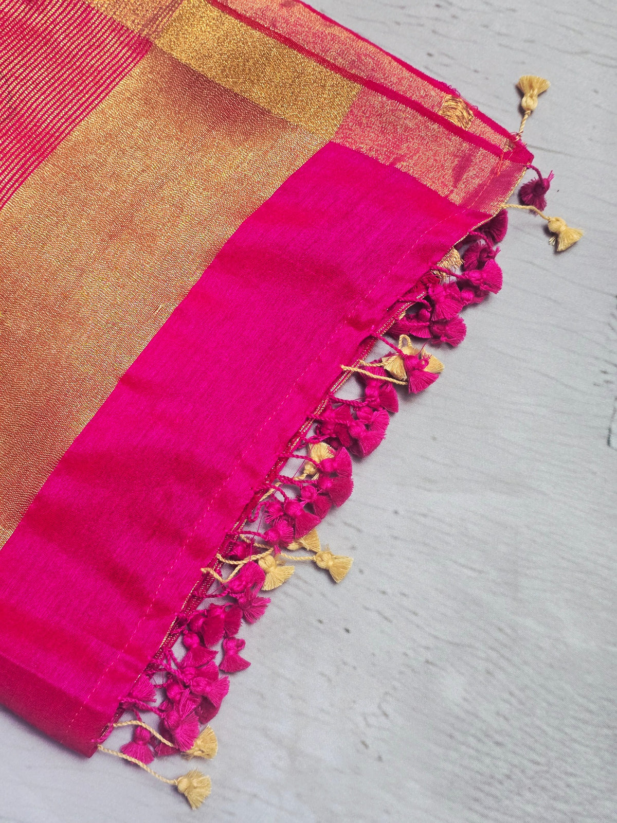 Vivid fuchsia pink Mul Cotton saree close-up with tassels and zari