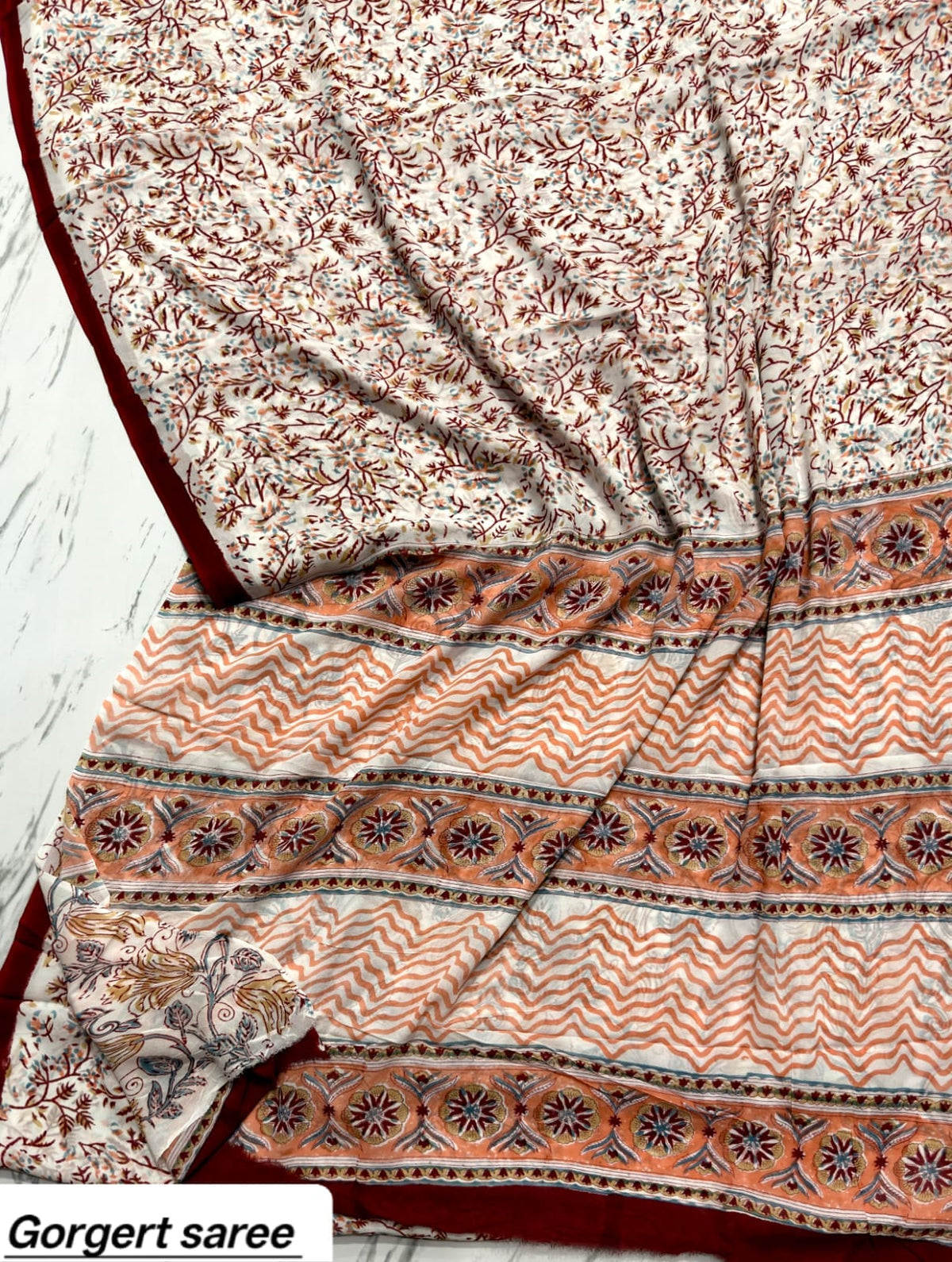 Ivory georgette saree with rust floral vines and peach patterned pallu