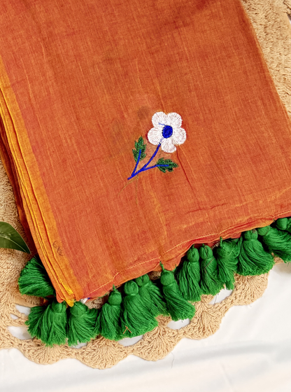 Rust Orange Mul Cotton Saree with Floral Embroidery & Green Tassels