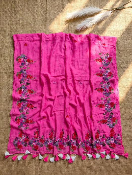 Bright pink mul cotton saree with multicolour floral embroidered borders and pink and white tassels